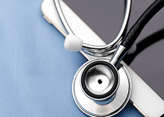 A stethoscope rests on top of a smartphone, both placed on a light blue surface, symbolizing the intersection of healthcare and technology.